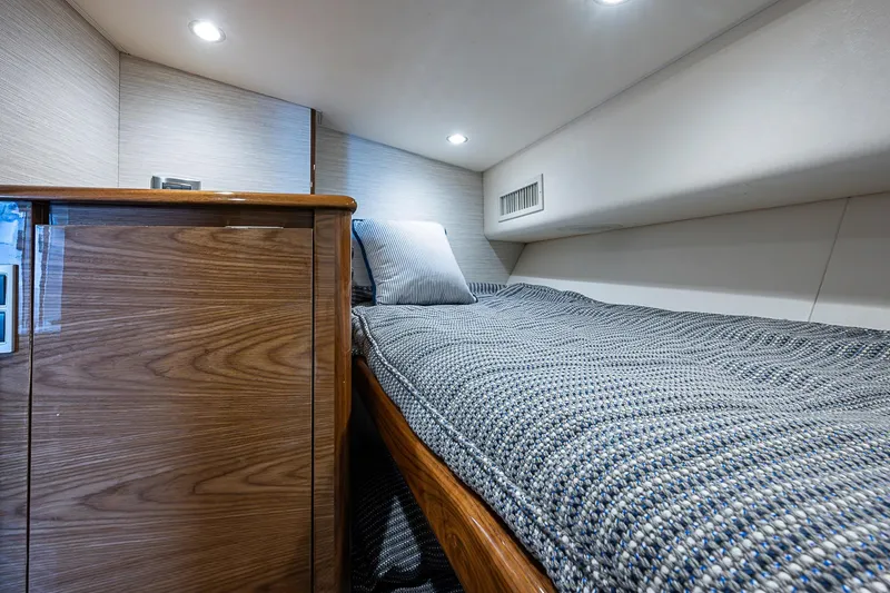 Slide: The Image of 2023 Viking 48 Sport Tower cabin interior with cozy bed and wooden cabinetry. - 17