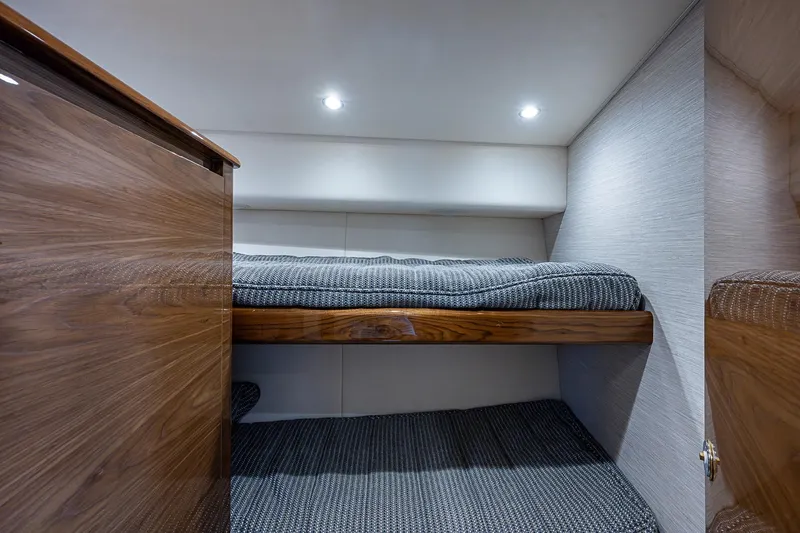Slide: The Image of 2023 Viking 48 Sport Tower cabin with wooden bunk beds and modern lighting. - 18