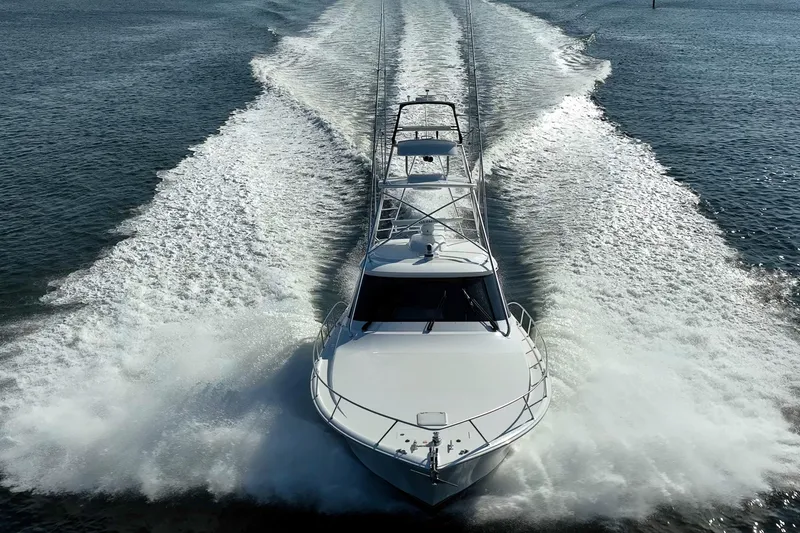 Slide: The Image of 2023 Viking 48 Sport Tower cruising swiftly on open water. - 2