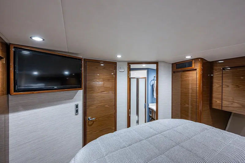 Slide: The Image of Luxurious interior of 2023 Viking 48 Sport Tower yacht cabin with TV and wood finishes. - 20