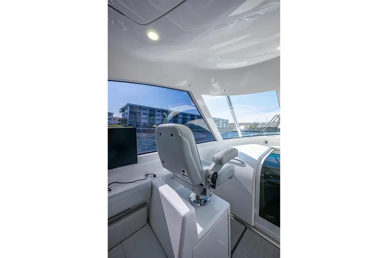 Slide: The Image of Interior of 2023 Viking 48 Sport Tower yacht with modern helm and panoramic windows. - 24