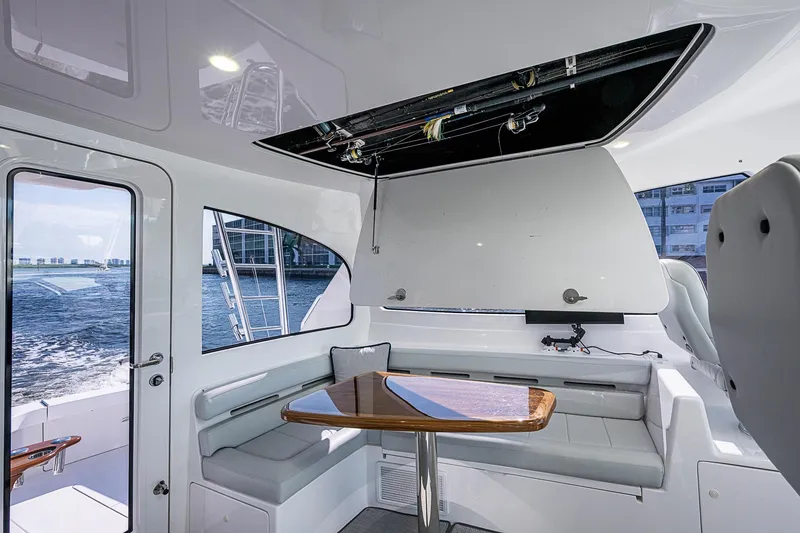 Slide: The Image of Interior of 2023 Viking 48 Sport Tower yacht with seating and table, overlooking water. - 25