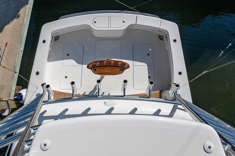 Slide: The Image of 2023 Viking 48 Sport Tower boat deck with fishing rod holders and teak accents. - 30