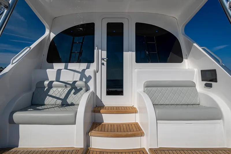 Slide: The Image of 2023 Viking 48 Sport Tower yacht interior with elegant seating and wooden steps. - 39