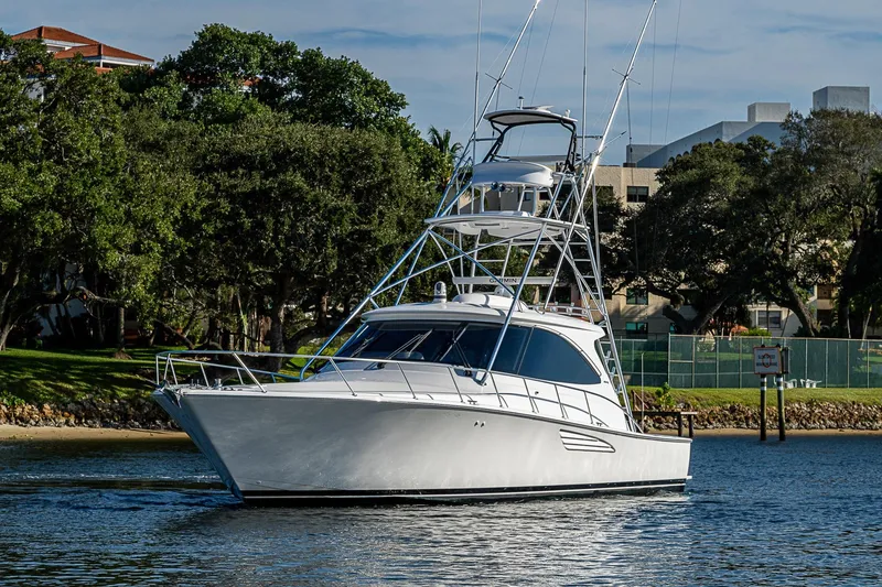 Slide: The Image of 2023 Viking 48 Sport Tower yacht cruising on a serene waterway. - 61