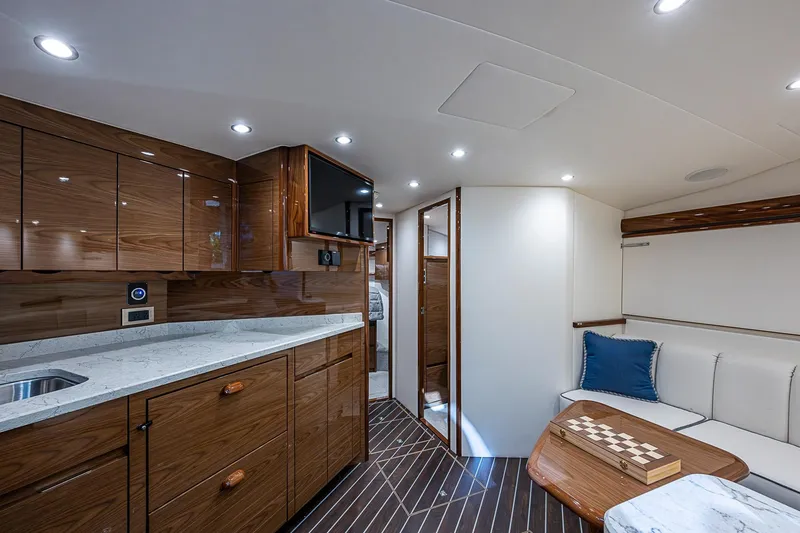 Slide: The Image of Luxurious interior of 2023 Viking 48 Sport Tower yacht with modern wood cabinetry and seating. - 8