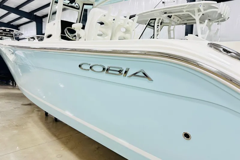 Slide: The Image of 2026 Cobia 285 Center Console boat in showroom, side view. - 16