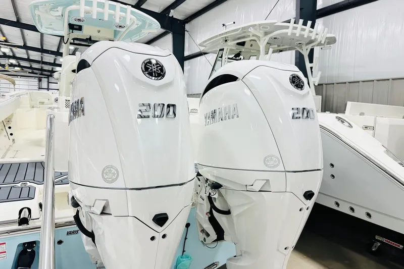 Slide: The Image of 2026 Cobia 285 Center Console with dual Yamaha 200 engines in a showroom. - 17