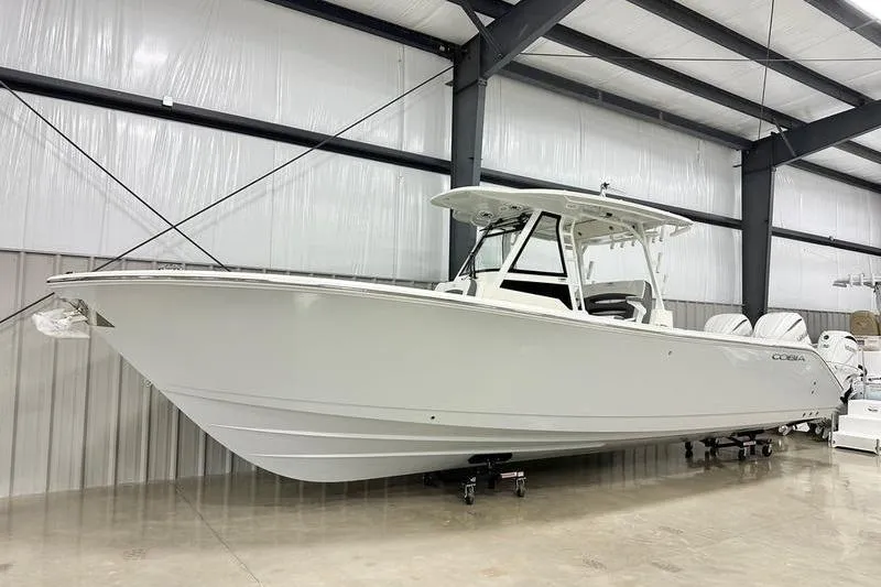 The Image of 2026 Cobia 305 Center Console boat in a spacious indoor showroom. - 1