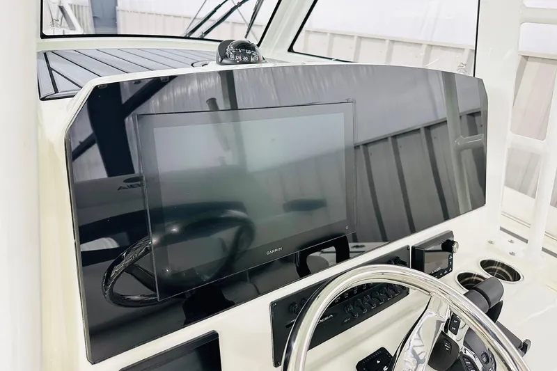 Slide: The Image of 2026 Cobia 305 Center Console dashboard with Garmin display and steering wheel. - 3