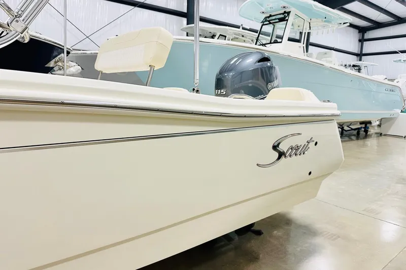 Slide: The Image of 2026 Scout 188 Sportfish boat in showroom, featuring sleek design and Yamaha engine. - 11