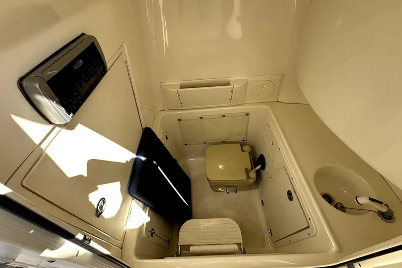 Slide: The Image of 2005 Boston Whaler 270 Outrage cabin interior with toilet and sink. - 23