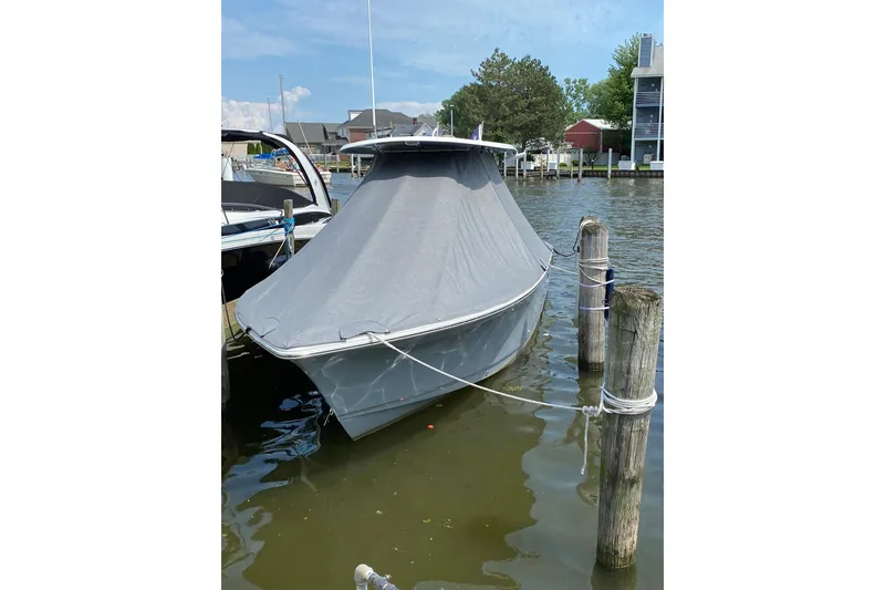 Slide: The Image of 2021 Sea Hunt Ultra 255 SE boat covered and docked in a marina. - 1