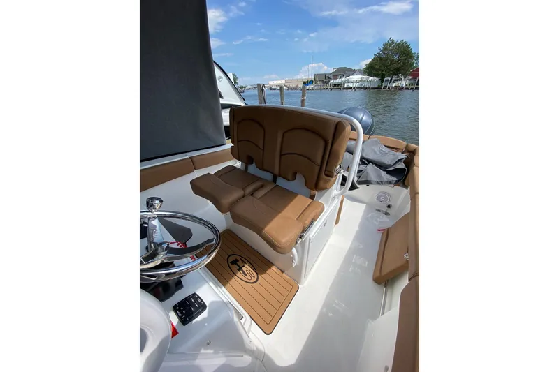 Slide: The Image of 2021 Sea Hunt Ultra 255 SE boat interior with brown seating and steering wheel. - 15