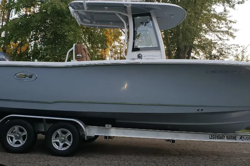 Slide: The Image of 2021 Sea Hunt Ultra 255 SE boat on trailer, parked outdoors. - 2