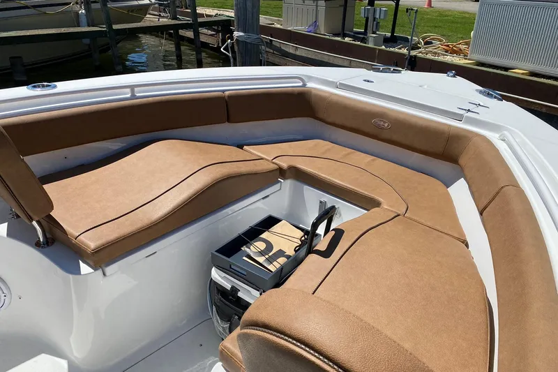 Slide: The Image of 2021 Sea Hunt Ultra 255 SE boat with tan cushioned seating and storage compartment. - 21