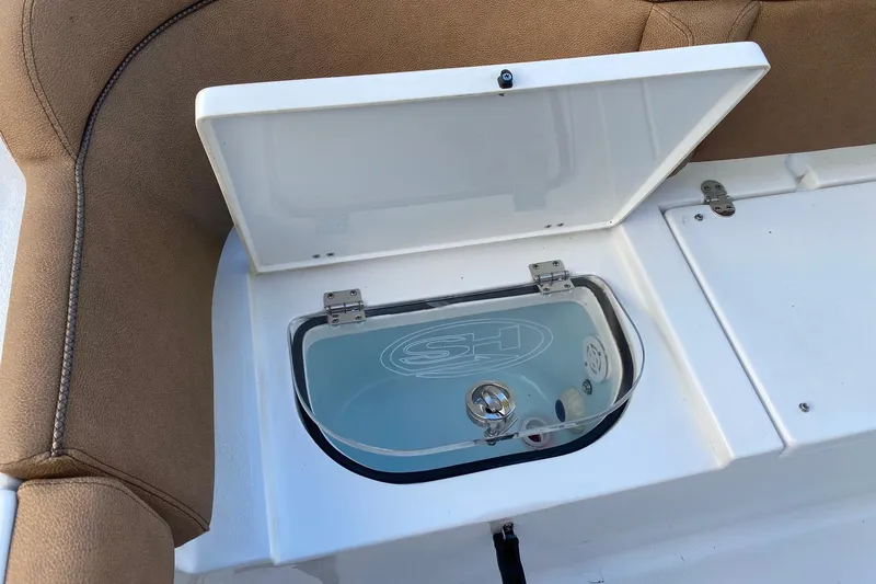 Slide: The Image of Open storage compartment on 2021 Sea Hunt Ultra 255 SE boat, featuring cushioned seating. - 4