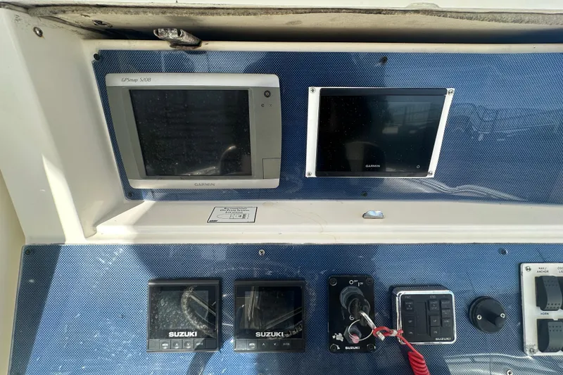 Slide: The Image of Dashboard of a 2004 Marlago 35 FS boat with Garmin and Suzuki electronics. - 16