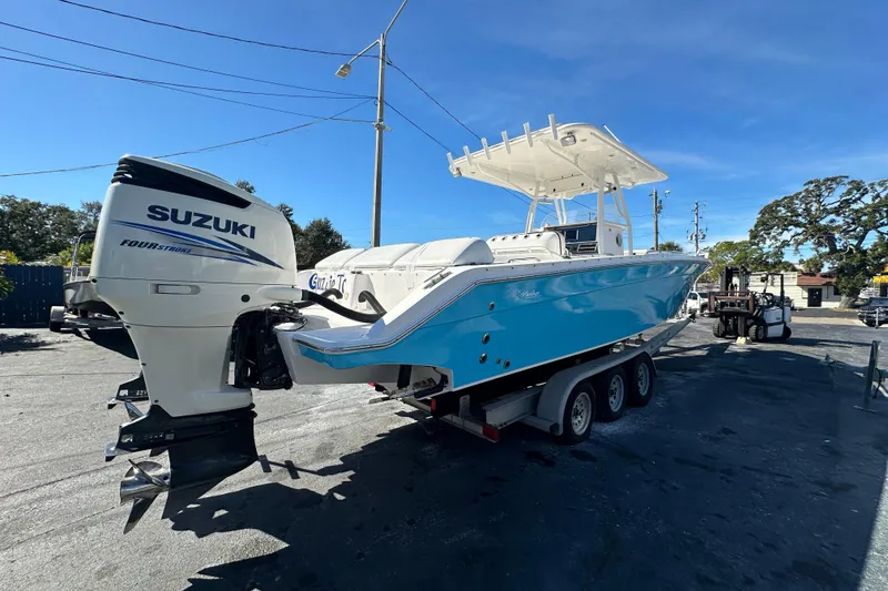Slide: The Image of 2004 Marlago 35 FS boat with Suzuki outboard engine on a trailer, parked outdoors. - 4