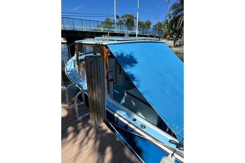 The Image of Blue Duffy 26 boat docked, featuring a canopy and wooden accents. - 1