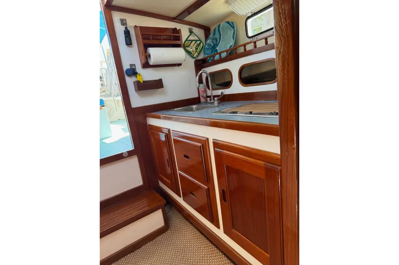 Slide: The Image of Cozy Duffy 26 boat kitchen with wooden cabinets and stainless steel sink. - 10
