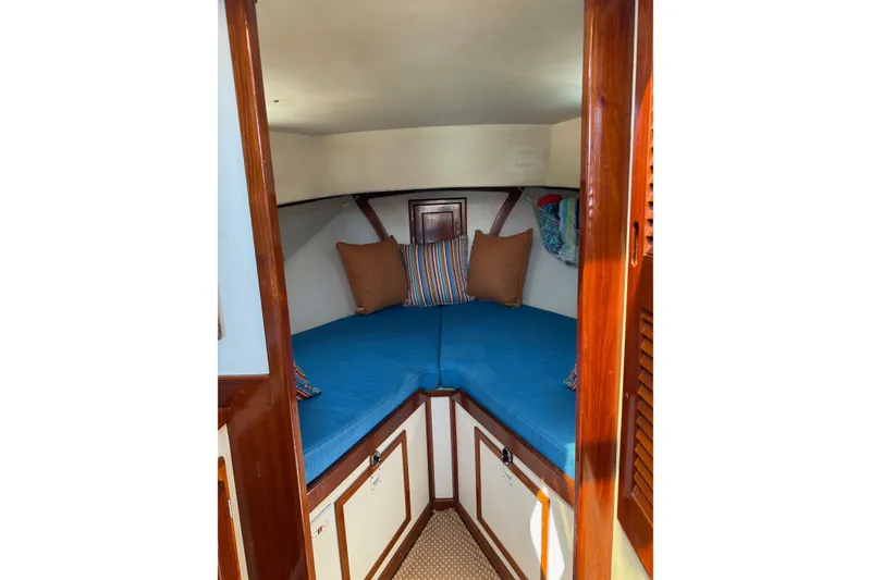 Slide: The Image of Cozy cabin interior of a Duffy 26 boat with blue cushions and wooden accents. - 12