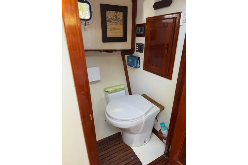 Slide: The Image of Boat bathroom interior with toilet, wooden accents, and framed decor on a Duffy 26 model. - 13