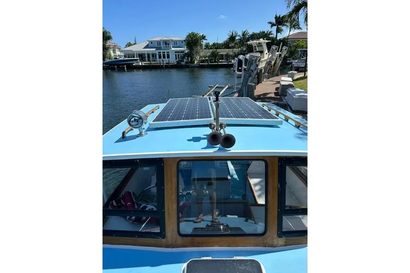 Slide: The Image of Duffy 26 boat with solar panels docked by waterfront homes. - 16