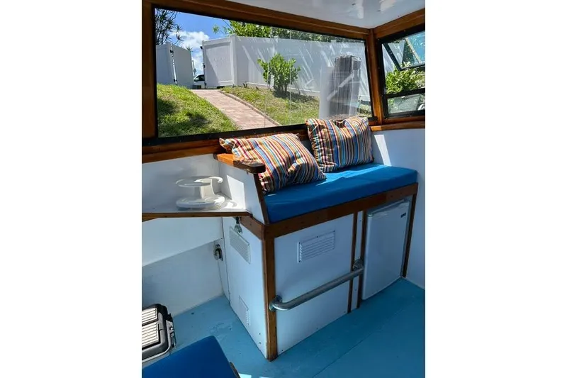 Slide: The Image of Interior of a Duffy 26 boat with striped cushions and a small fridge. - 9