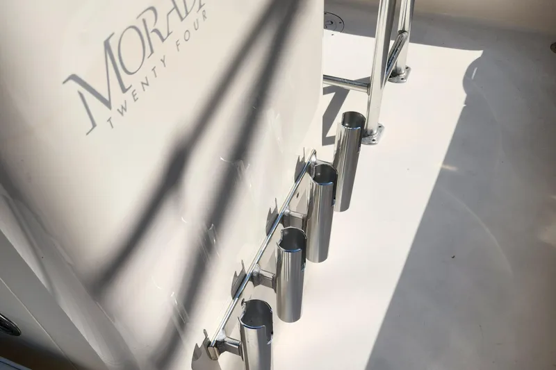 Slide: The Image of 2014 Islamorada Boatworks Morada 24, spacious deck, white seating, parked outdoors. - 10