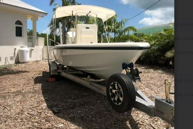Slide: The Image of 2014 Islamorada Boatworks Morada 24, spacious deck, white seating, parked outdoors. - 5