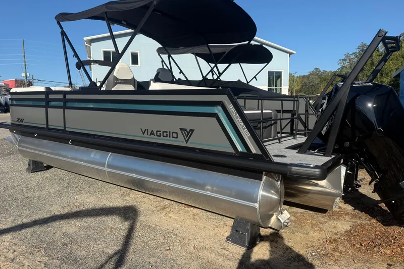 Slide: The Image of 2026 Viaggio Lago Z-S pontoon boat with canopy, parked on gravel. - 2