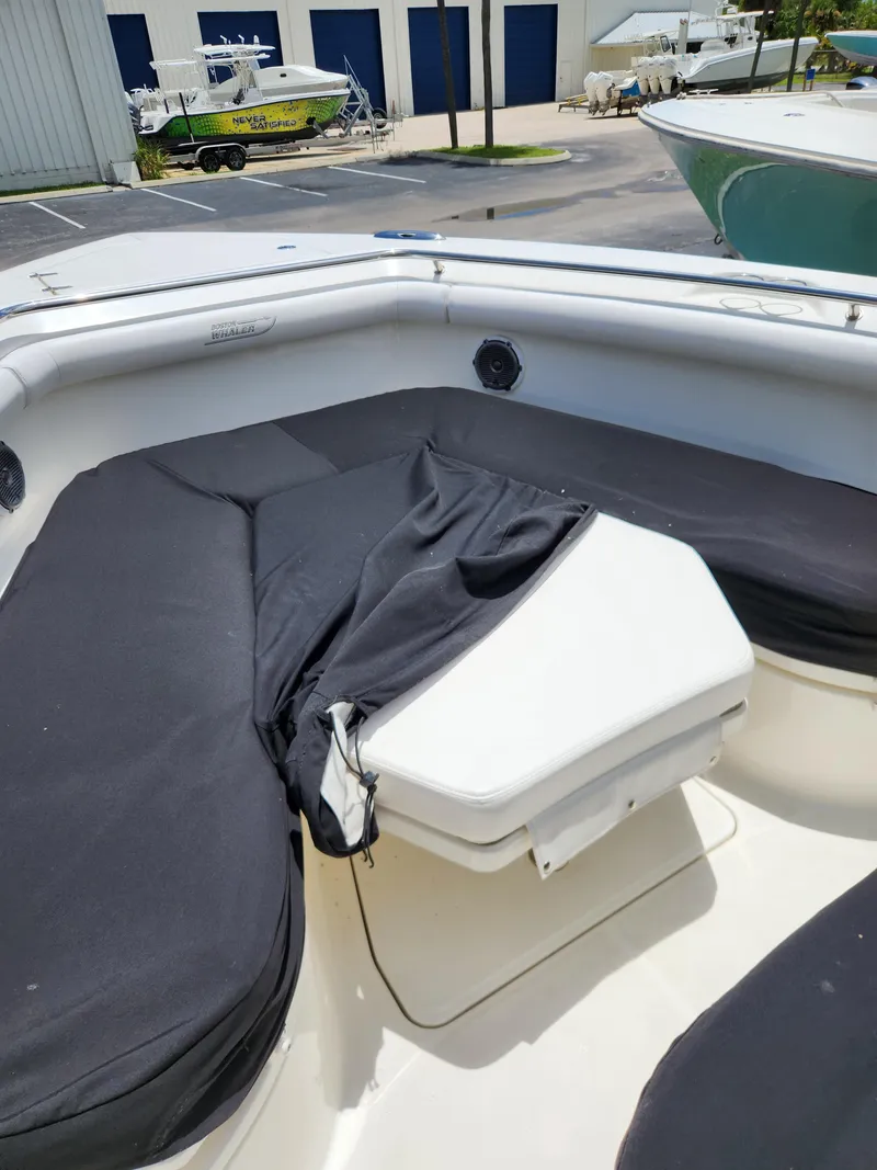 Slide: The Image of 2014 Boston Whaler 350 Outrage boat interior with cushioned seating. - 15