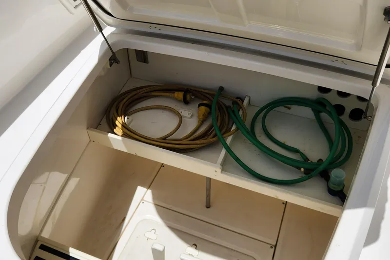 Slide: The Image of Storage compartment of a 2014 Boston Whaler 350 Outrage boat with hoses. - 22