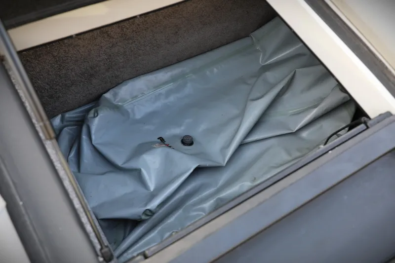 Slide: The Image of Storage compartment of 2016 Malibu Wakesetter 20 VTX with a folded gray cover. - 13