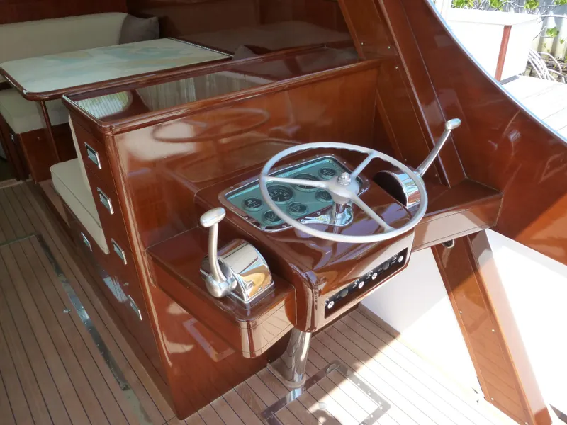 Slide: The Image of 1949 Rybovich Sport Fish boat helm with polished wood and classic steering wheel. - 23