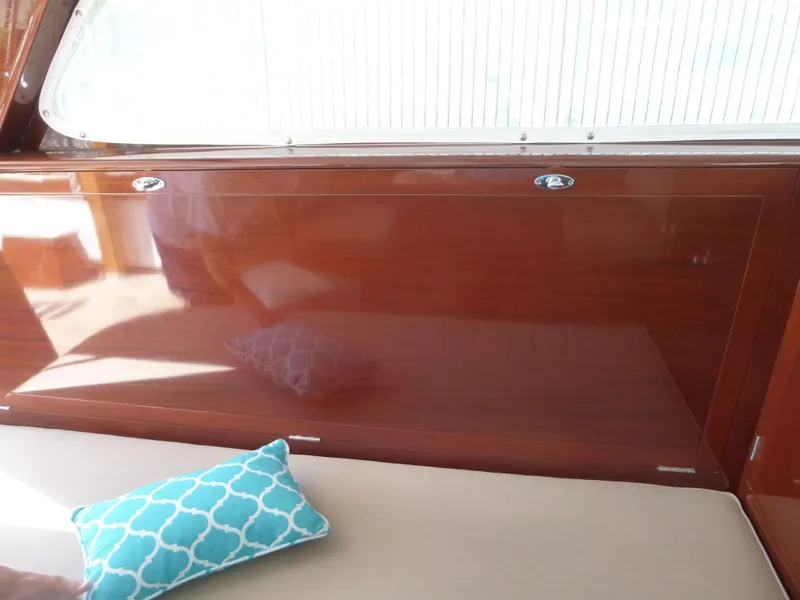 Slide: The Image of 1949 Rybovich Sport Fish interior with polished wood and decorative cushion. - 26