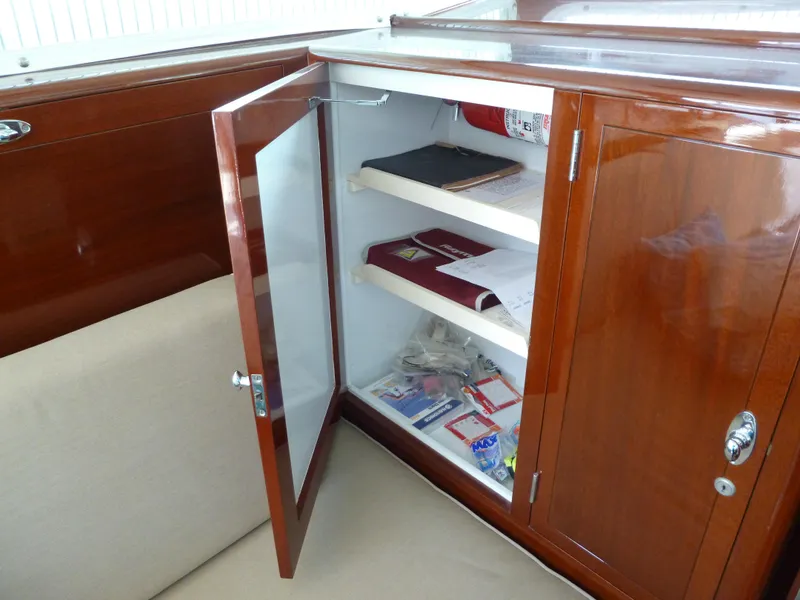 Slide: The Image of 1949 Rybovich Sport Fish interior with open wooden cabinet and shelves. - 30