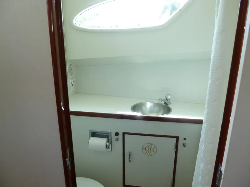Slide: The Image of 1949 Rybovich Sport Fish boat bathroom with sink, toilet, and oval window. - 47