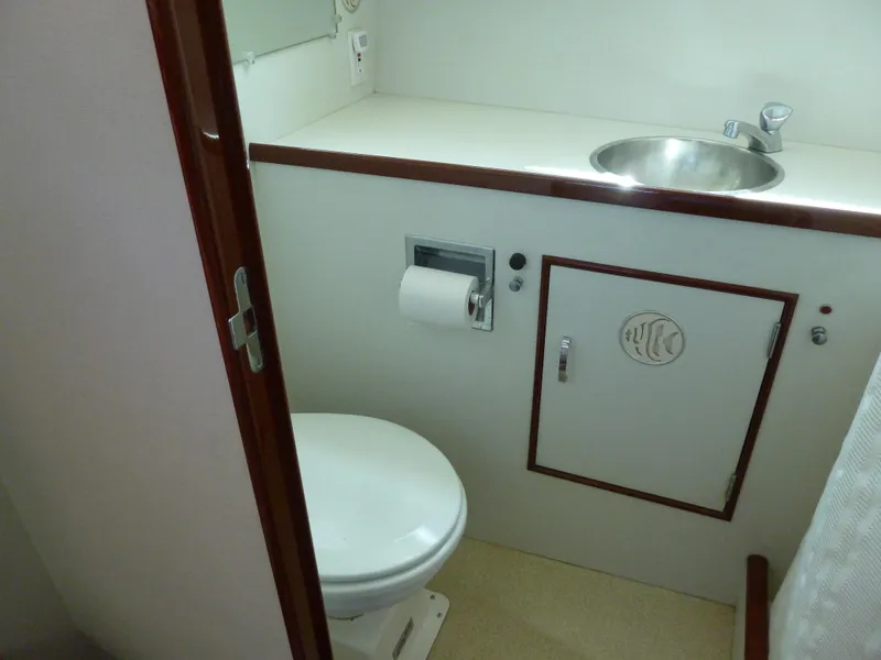 Slide: The Image of 1949 Rybovich Sport Fish boat bathroom with toilet, sink, and storage cabinet. - 48