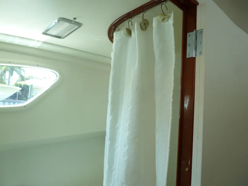 Slide: The Image of 1949 Rybovich Sport Fish interior with white curtain and wooden trim. - 49