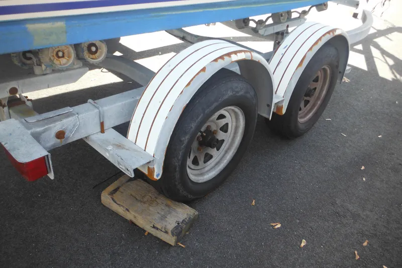 Slide: The Image of Trailer for 1998 Pro-Line 201 Walkaround boat with dual wheels on pavement. - 11