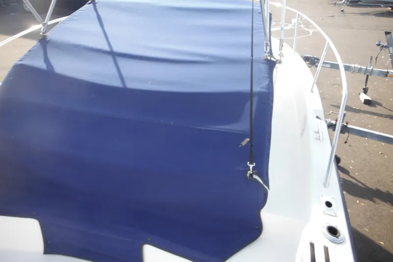 Slide: The Image of 1998 Pro-Line 201 Walkaround boat with blue cover on trailer. - 16