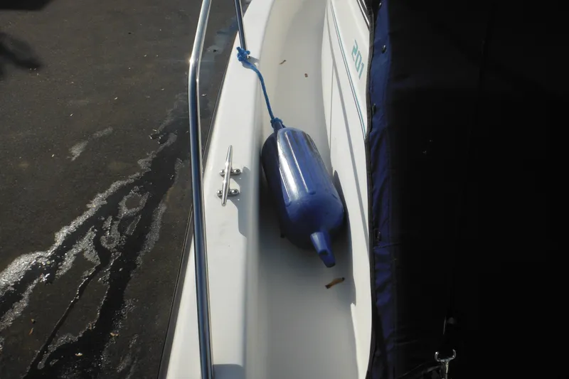 Slide: The Image of 1998 Pro-Line 201 Walkaround boat with blue fender on deck. - 18