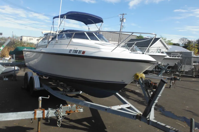 Slide: The Image of 1998 Pro-Line 201 Walkaround boat on trailer, parked outdoors under blue sky. - 2