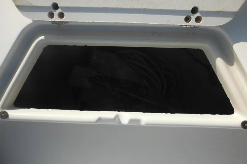 Slide: The Image of Open storage compartment on 1998 Pro-Line 201 Walkaround boat, containing coiled rope. - 22