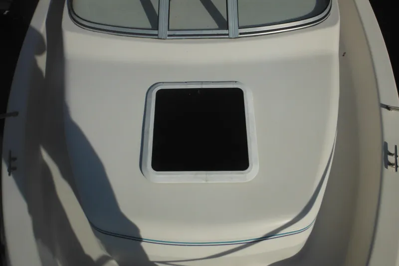 Slide: The Image of 1998 Pro-Line 201 Walkaround boat deck with open hatch, showcasing sleek design. - 23