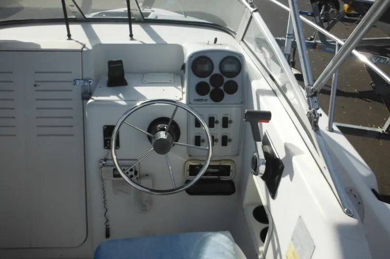 Slide: The Image of 1998 Pro-Line 201 Walkaround boat cockpit with steering wheel and control panel. - 28