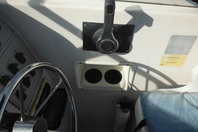 Slide: The Image of 1998 Pro-Line 201 Walkaround boat dashboard with steering wheel and controls. - 32