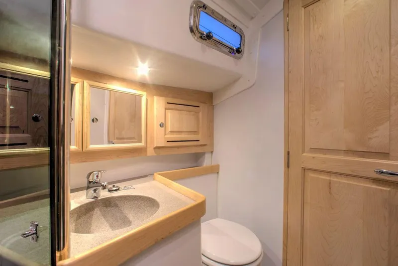 Slide: The Image of Manufacturer Provided Image: Modern Tartan 395 yacht bathroom, 2026 model, featuring wooden cabinetry and sleek fixtures. - 12